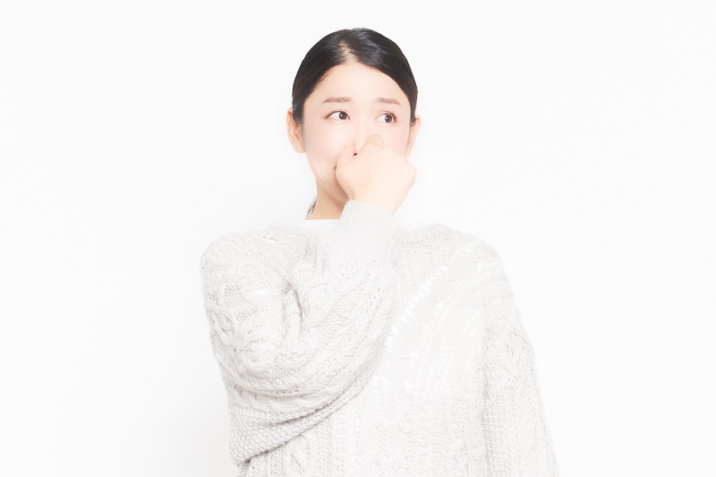 異臭に鼻をつまむ女性