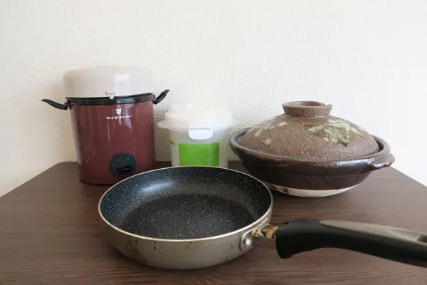今回使用したアイテム。右上から、土鍋、一合炊き容器、格安炊飯器、そして手前がフライパン