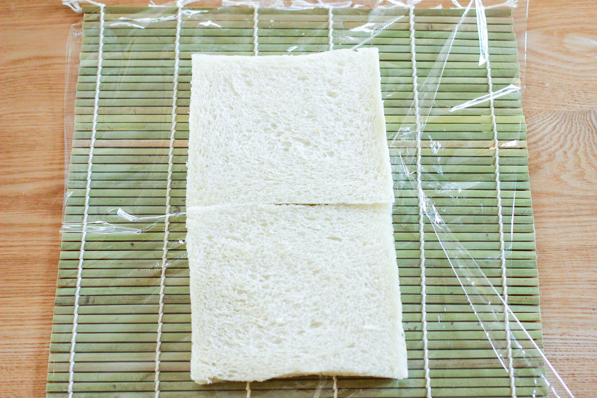 ラップは巻きすよりも大きめに用意。巻きすの上に食パンを縦に並べる