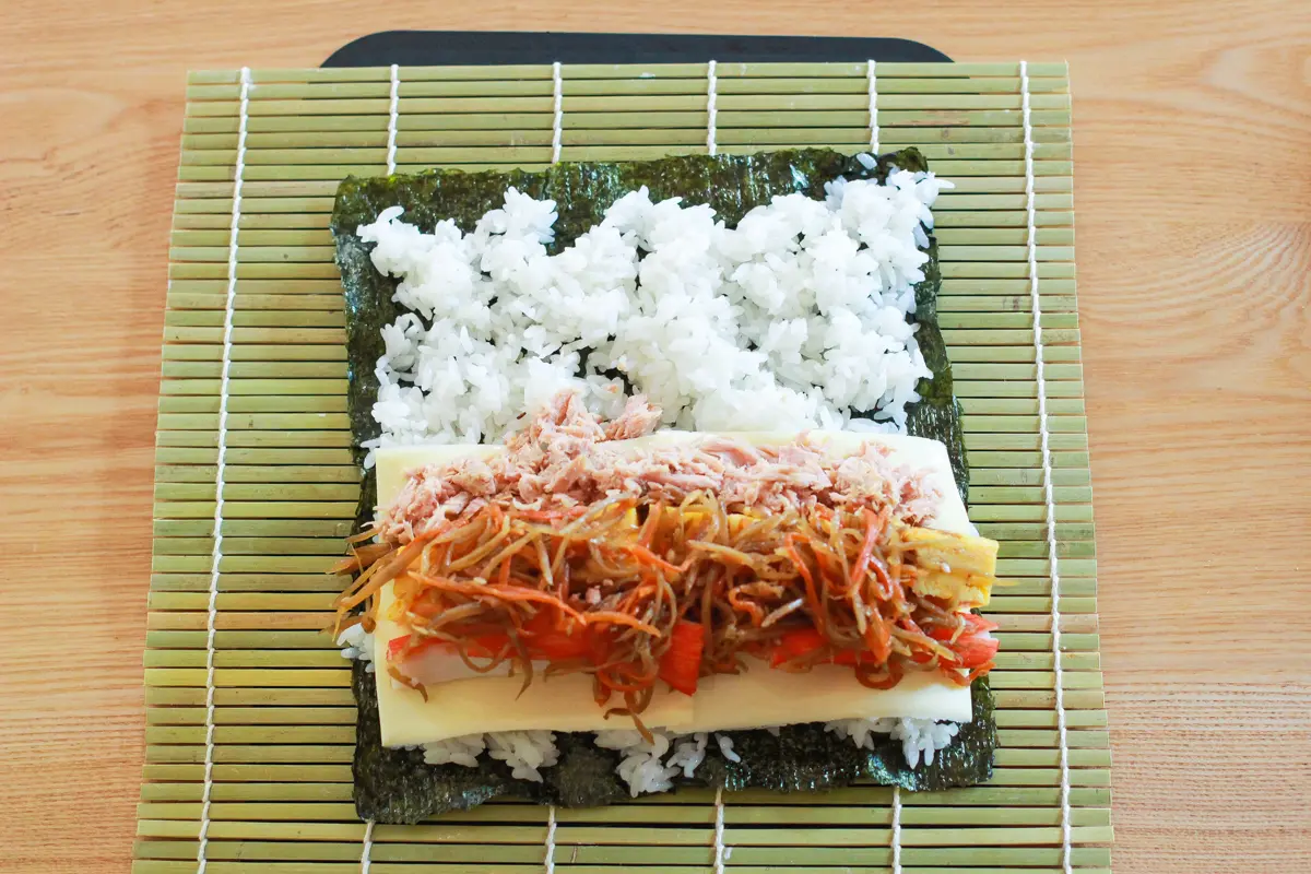 具材は多めがおいしい!手前から巻きすごと持ち上げて向こう側に引っ張るようにして巻く