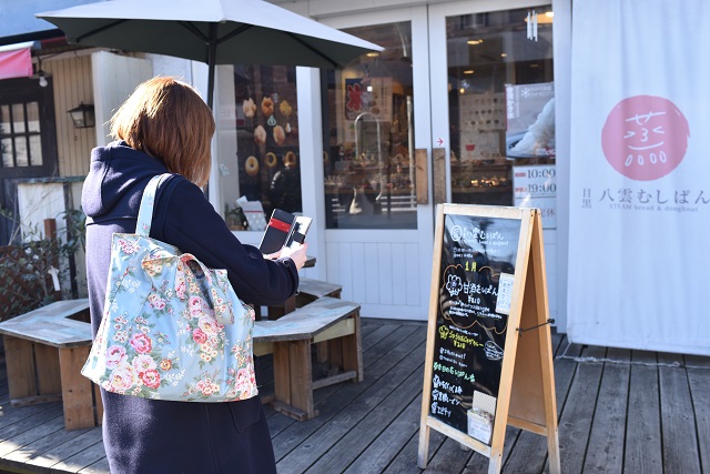 看板の新メニューをチェックする片山さん。自らの取材活動にも余念がない｜目黒八雲むしぱん