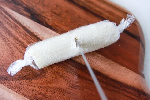 ラップごと押し切るとつぶれてしまうので、まず刃先を差し込む|コンビニ食材でつくるお花見弁当・ロールサンドイッチのレシピ