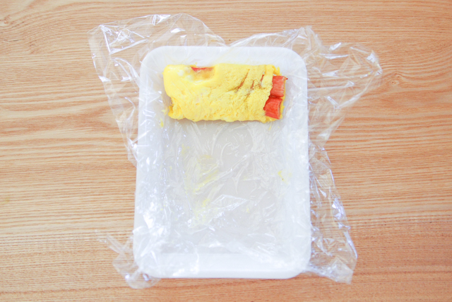 ラップをうまく使って卵を巻いていく|【コンビニ飯レシピ】10分でできちゃう!ラク早お弁当のおかずレシピ2選