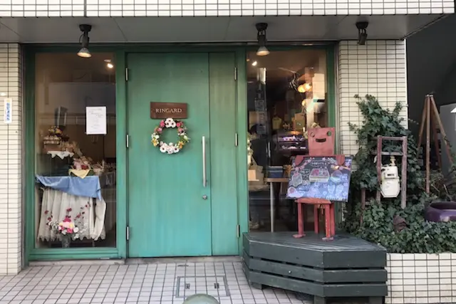 ペールグリーンのドアにフラワーリースがかわいらしい|ケーキ屋 ランギャール(王子)