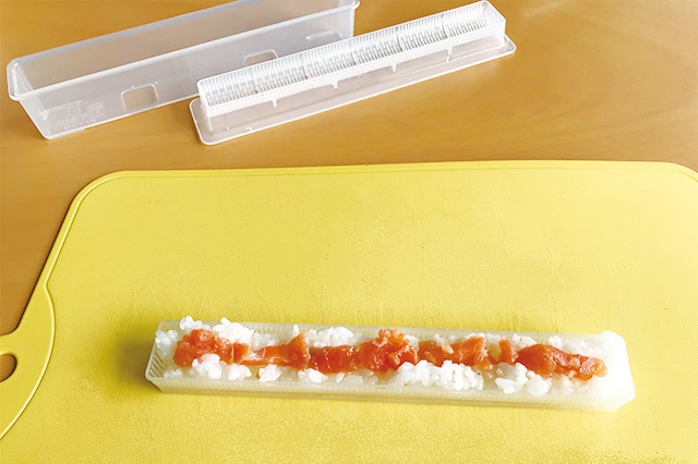 まずは「中子」に酢飯を8分目程度まで詰め、中央にくぼみをつけて具をのせる|寿司型 巻き寿司用 細巻き(ダイソー)|【100円ショップ・ダイソーの店長オススメ】こどもの日のホームパーティーにピッタリな100均グッズ9選