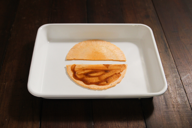割ったえびせんの半分にソースを塗り広げる|たこせんのレシピ|【コンビニ飯レシピ】5分で完成! ハイボールに合う簡単&絶品おつまみ3選