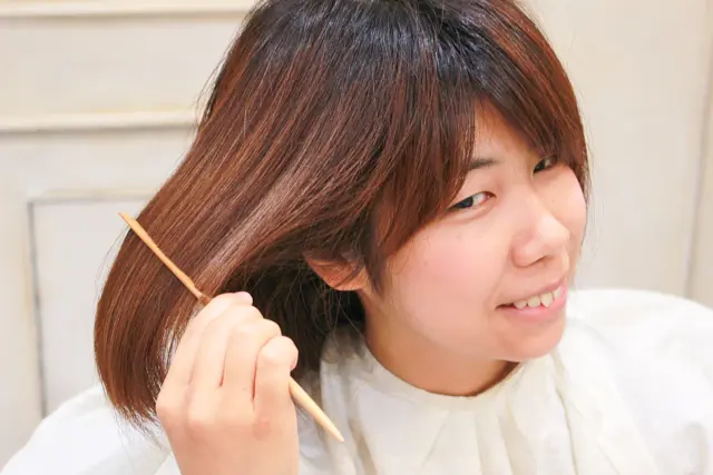 ミストを吹きかけた髪にクシを通している様子