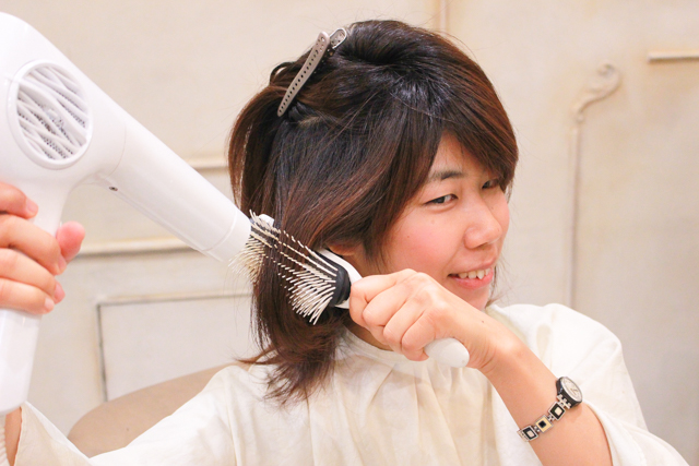 髪にブラシを通しながらドライヤーをあてる木村
