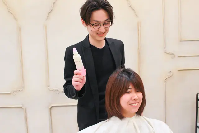 おすすめのヘアスプレーを持つ関田さん