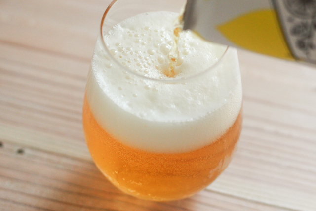 レモンビールをグラスに注ぐ