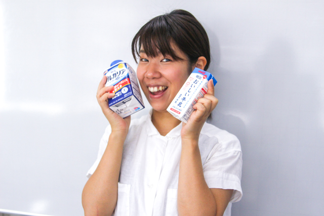 牛乳とヨーグルトを持って笑う木村