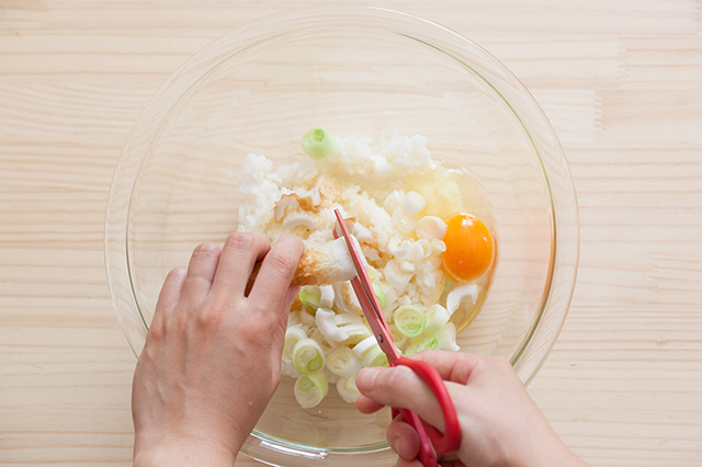 レンチンチャーハンの作り方：耐熱ボウルにごはん、卵、中華風顆粒だしを入れ、そのあと、カニカマ、ちくわ、ねぎをキッチンバサミで切りながら入れる