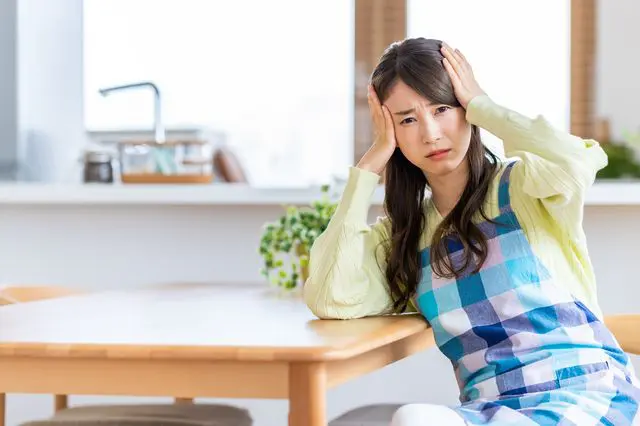 頭を抱えて悩む主婦