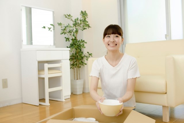 ダンボールから荷物を取り出す女性