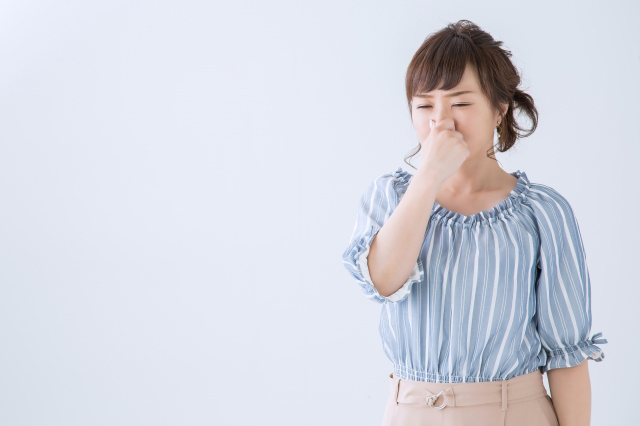 鼻をつまむ女性