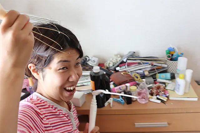 汚い机の前でヘッドマッサージする木村