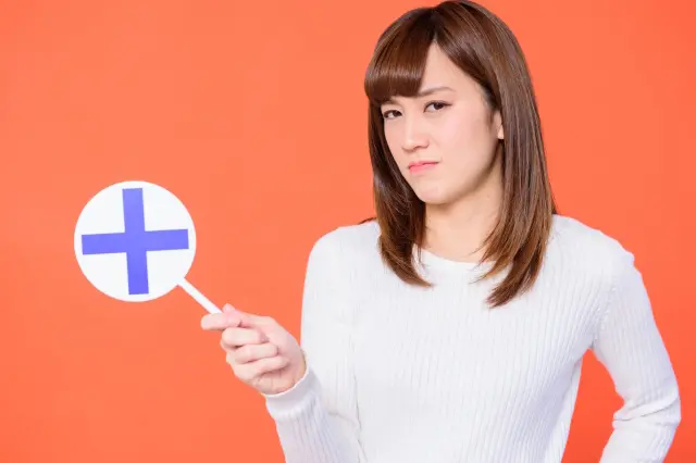 ×カードを持っていて不機嫌な女性