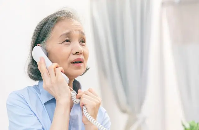 電話をかけるシニア女性