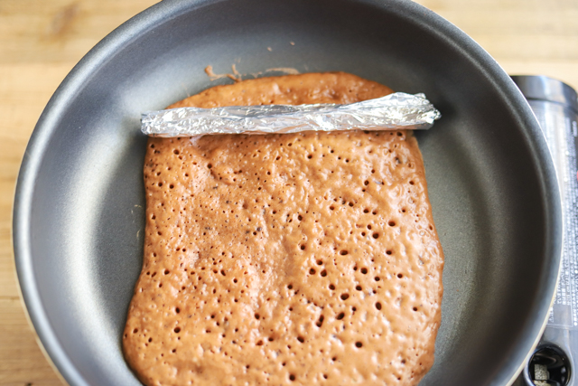 フライパンチョコバウムクーヘンの作り方:生地を芯棒に巻きつけるように、フライ返しで手前に巻いていく