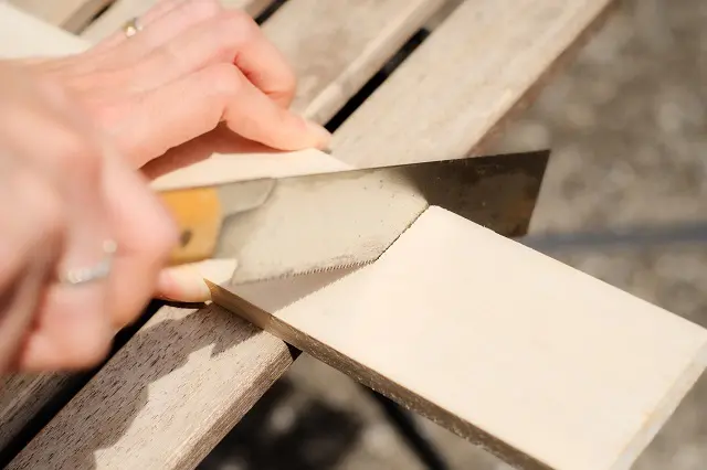 のこぎりで木材を切る様子