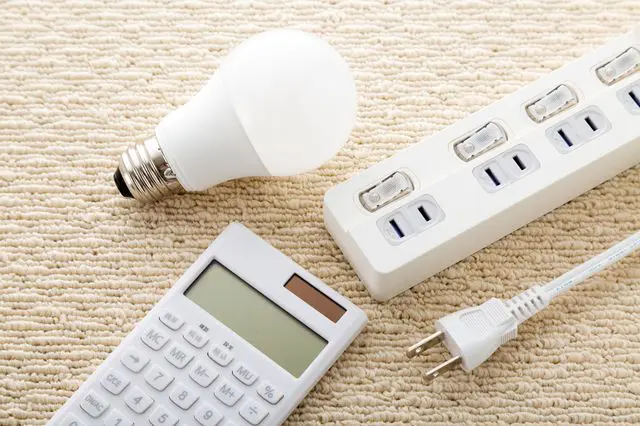 電球とコンセント、電卓のイメージ