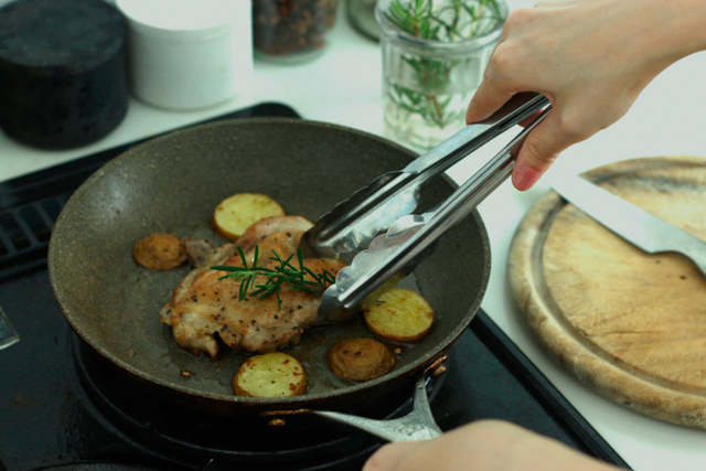 ハーブの寄植えから摘んだハーブを使って肉料理を作っている様子