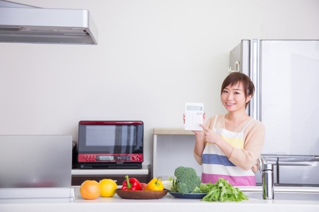 【二人暮らしの食費節約】電卓を持つ女性