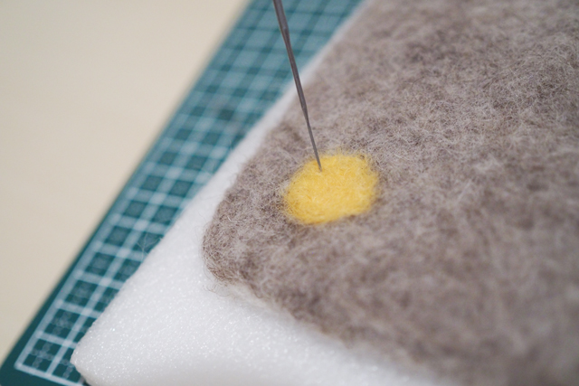 【100均DIY】ふんわりかわいい!羊毛フェルトを使った鍋敷きの作り方_水玉模様部分めフェルトをニードルで指していく様子