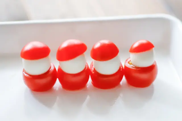 クリスマスパーティーを盛り上げる!カンタン・かわいい「フィンガーフード」のレシピ「プチトマトとうずらの卵のサンタクロース」の作り方:トマトと卵をつっつけた様子