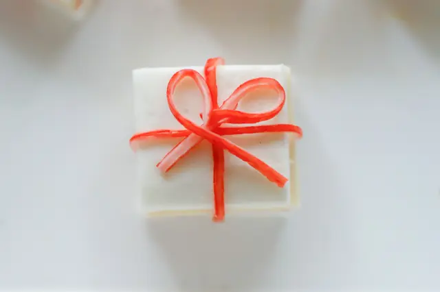 クリスマスパーティーを盛り上げる!カンタン・かわいい「フィンガーフード」のレシピ「はんぺんのクリスマスギフトボックス」の作り方:ハムとはんぺんを切る様子かにかまでリボンを作る様子