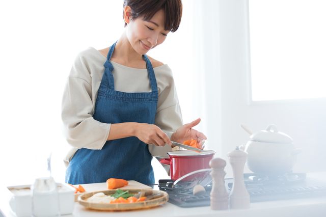 キッチンで料理する女性
