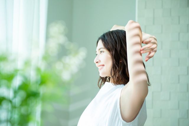 気持ちよく伸びをする一人暮らしの女性