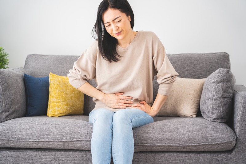 便秘解消レシピ お腹を押さえる女性