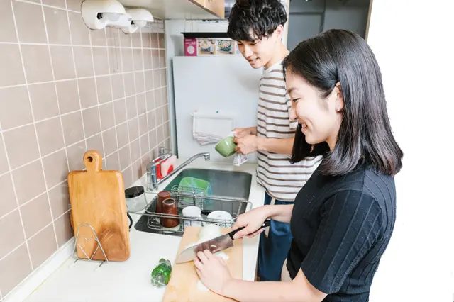 キッチンで一緒に料理をする同棲カップル