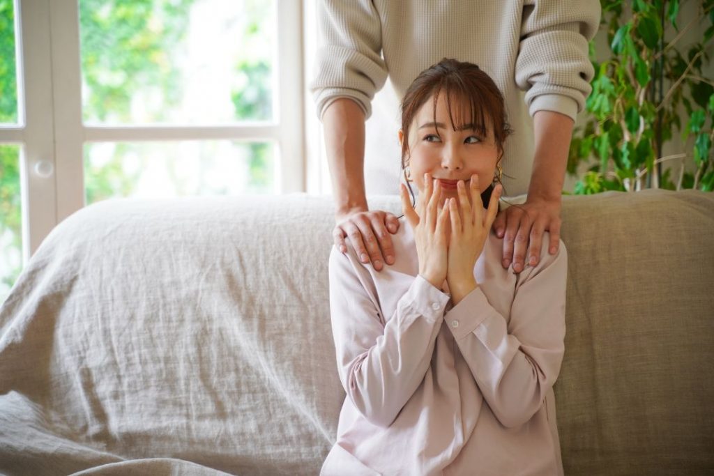 ソファーに座って嬉しそうにする女性