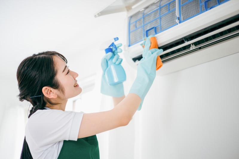 エアコンを掃除する女性