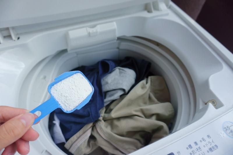 洗濯機の掃除　洗濯機に洗剤を入れる様子
