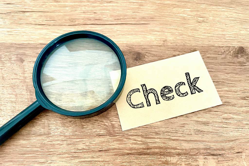 虫眼鏡と「Check」と書かれた付箋の写真